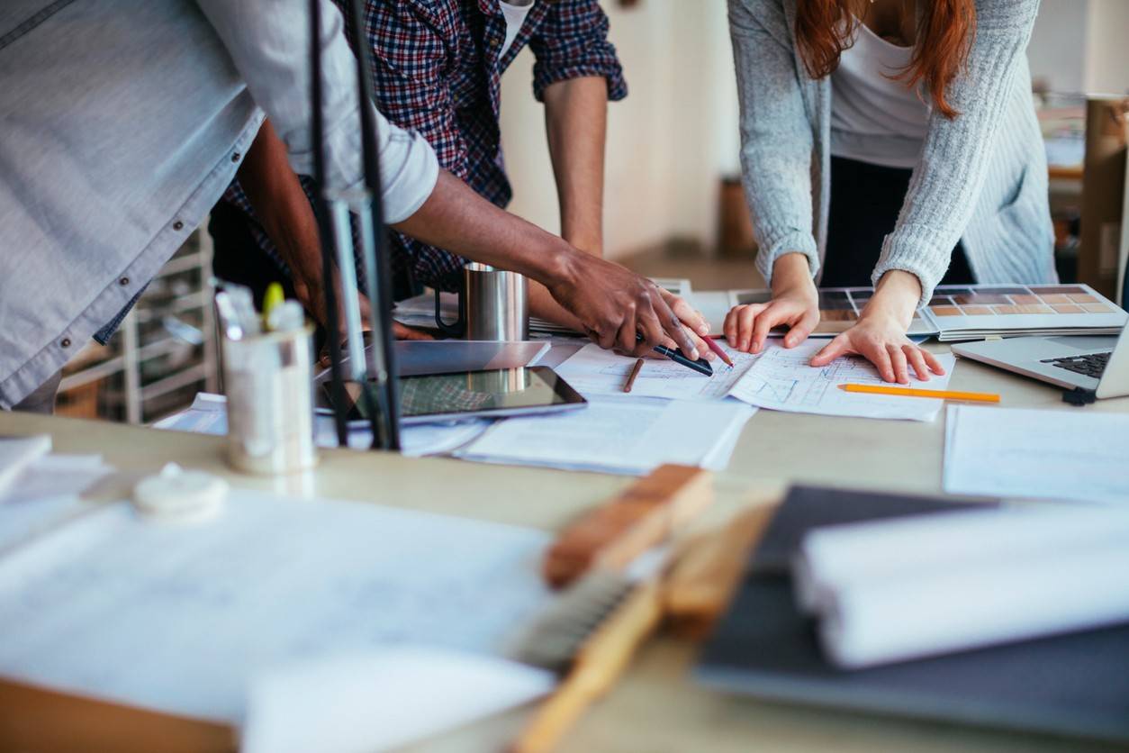 a decorative picture of creative professionals reviewing schematics